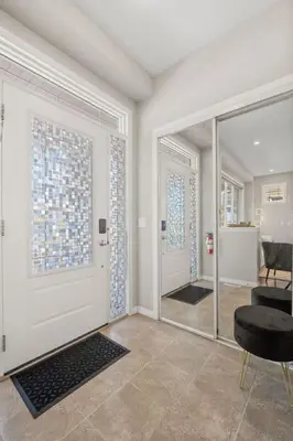 a living room with a glass door and a chair at Large House with Billiards, 5 Bedrooms, Garage Parking & Free Banff Access in Calgary