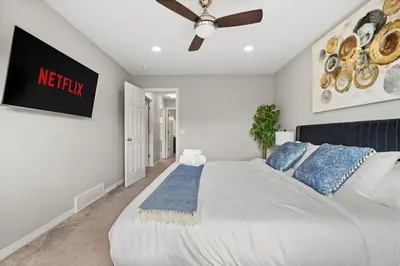 a bedroom with a large bed with a ceiling fan at Large House with Billiards, 5 Bedrooms, Garage Parking & Free Banff Access in Calgary