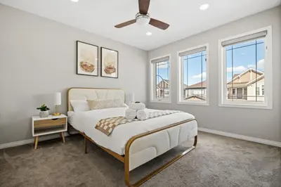 a white bedroom with a bed and windows at Large House with Billiards, 5 Bedrooms, Garage Parking & Free Banff Access in Calgary