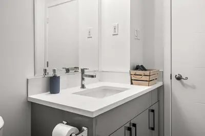 a white bathroom with a sink and a mirror at Bright 3-Bed Retreat Near the Zoo and Downtown in Calgary