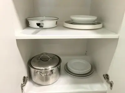 two shelves with dishes and a pot and plates at Private Cozy 2bdrm Sleep5pp Metrotown! Free Parking! Self Check-in! in Burnaby