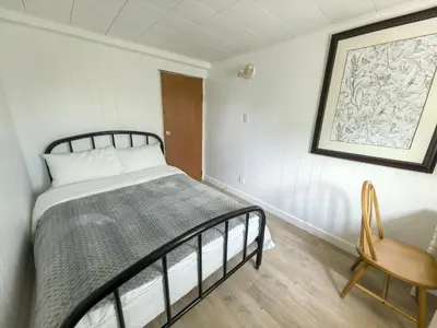 a bedroom with a bed and a chair in it at Private Cozy 2bdrm Sleep5pp Metrotown! Free Parking! Self Check-in! in Burnaby