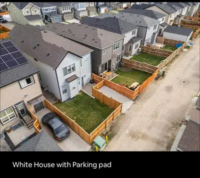 an aerial view of a white house with parking pad at Brand new suite with parking pad at the back in Calgary