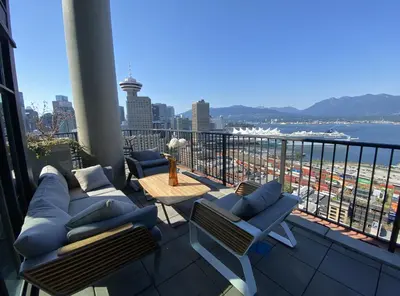 a balcony with couches and a view of the ocean at 3-Level Modern Luxury Sub-Penhouse, Best Ocean & City Views - Prime Downtown Location in Vancouver