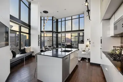 an open kitchen and living room with large windows at 3-Level Modern Luxury Sub-Penhouse, Best Ocean & City Views - Prime Downtown Location in Vancouver