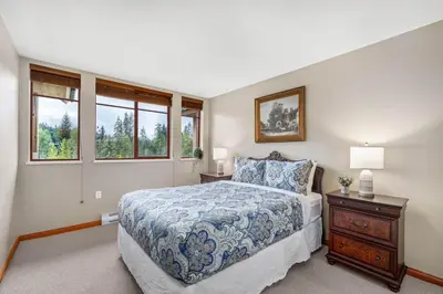 a bedroom with a bed and two windows at 2BR in Nicklaus North, Mountain Views, Bright and Spacious, Tranquil Location in Whistler