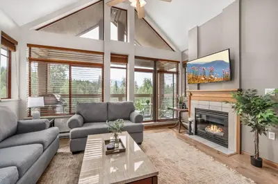 a living room with a couch and a fireplace at 2BR in Nicklaus North, Mountain Views, Bright and Spacious, Tranquil Location in Whistler