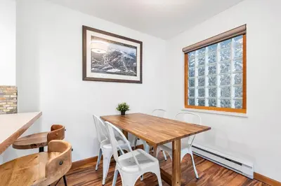 a dining room with a wooden table and chairs at 1BR in Northstar, Village Location, Hot Tub, Gas Fireplace, Secure Parking, Ski Storage in Whistler
