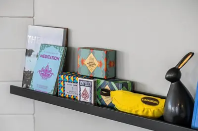 a shelf with boxes and books and a yellow banana at Lakefront Lookout 1BR Condo on Lakeshore Drive in Sylvan Lake