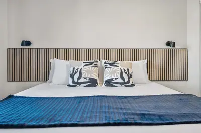 a bed with four pillows on top of it at Lakefront Lookout 1BR Condo on Lakeshore Drive in Sylvan Lake