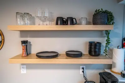 a shelf with plates and glasses on it at The Rosemead Suite in Kelowna