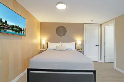 a bedroom with a bed and a large window at The Rosemead Suite in Kelowna