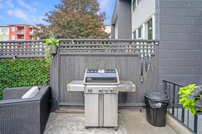 a grill in front of a fence next to a house at The Rosemead Suite in Kelowna