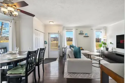 a dining room and living room with a dining table at Cozy Modern Pet Friendly Homes in Calgary
