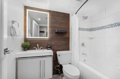 a bathroom with a toilet and a sink and a mirror at 1BR and Den in Marketplace Lodge, Village Location, Mountain Views, Gas Fireplace, Parking in Whistler