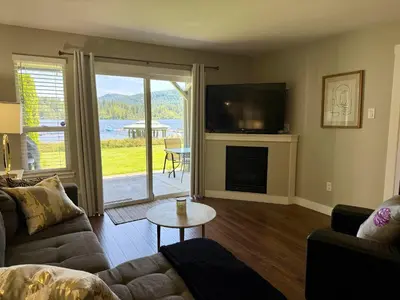 a living room with a couch and a television and a fireplace at Lakefront Suite on Shawnigan Lake in Shawnigan Lake