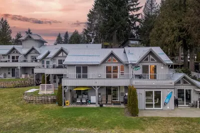 a large white house with a yard at Lakefront Suite on Shawnigan Lake in Shawnigan Lake