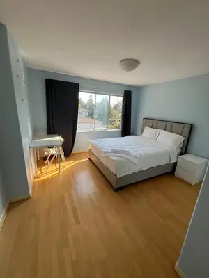a bedroom with a bed and a desk and a window at Luxurious and quiet room in Vancouver's West End in Vancouver
