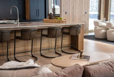 a kitchen with a counter with bar stools at Mountain Lake Luxury Ski Chalet in Revelstoke
