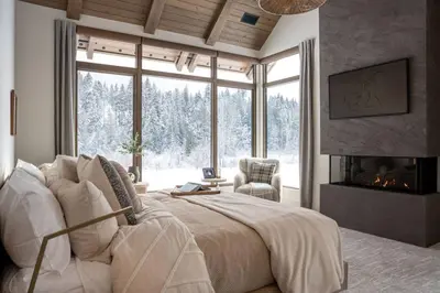 a bedroom with a large bed and a fireplace at Mountain Lake Luxury Ski Chalet in Revelstoke