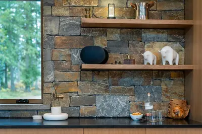 a stone wall with shelves on a kitchen counter at Mountain Lake Luxury Ski Chalet in Revelstoke
