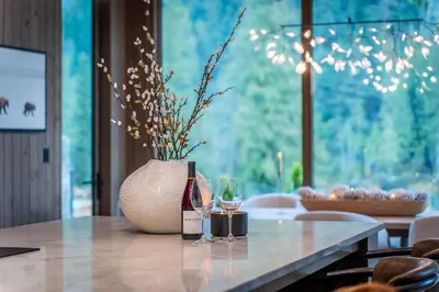 a table with two wine glasses and a vase at Mountain Lake Luxury Ski Chalet in Revelstoke