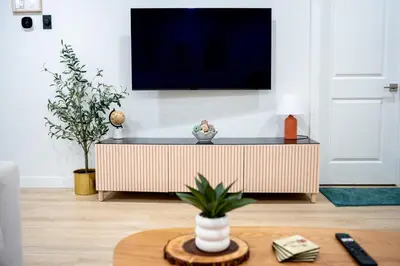 a living room with a tv on a wall at Modern Luxury Stay - Airport, Banff, Rockies Route in Calgary