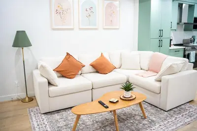 a living room with a white couch and a table at Modern Luxury Stay - Airport, Banff, Rockies Route in Calgary