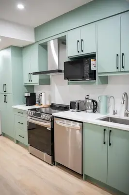 a kitchen with blue cabinets and a stove top oven at Modern Luxury Stay - Airport, Banff, Rockies Route in Calgary