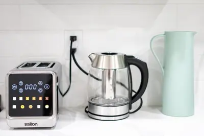 a blender and a alarm clock on a counter next to a toaster at Modern Luxury Stay - Airport, Banff, Rockies Route in Calgary