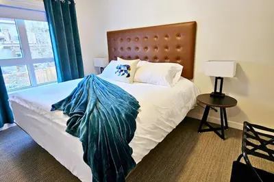 a bedroom with a bed with a blue blanket on it at Cloudline Vista 3 BdrmTownhouse with Garage managed by Little Sister Getaways in Canmore
