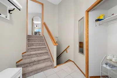 a staircase in a home with white walls at Peacock Suites in Airdrie