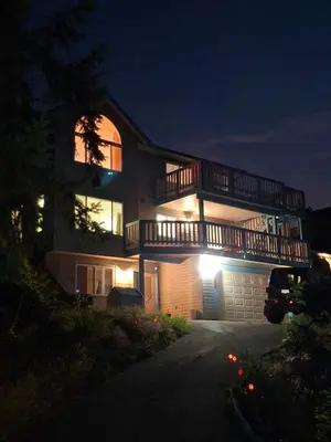 a large house with a balcony on top of it at night at Blue Villa by the Sea in Sechelt