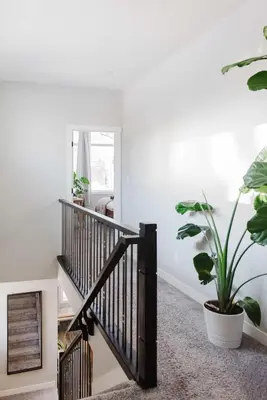 a hallway with a staircase with a potted plant at NordicSauna 3 Ensuite baths TheYellowDoorRetreat in Edmonton