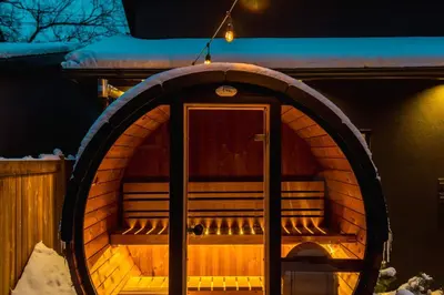 a wooden sauna with a door in the snow at NordicSauna 3 Ensuite baths TheYellowDoorRetreat in Edmonton
