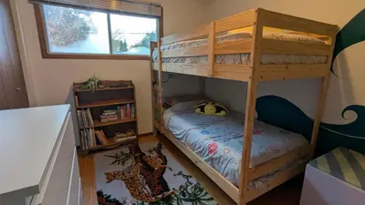 a bedroom with two bunk beds and a book shelf at YEGFamilyHome in Edmonton
