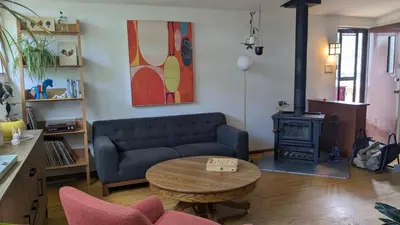 a living room with a couch and a table and a stove at YEGFamilyHome in Edmonton