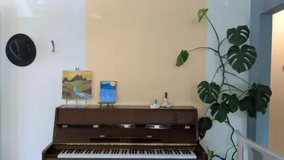 a piano sitting in a room with a plant at YEGFamilyHome in Edmonton
