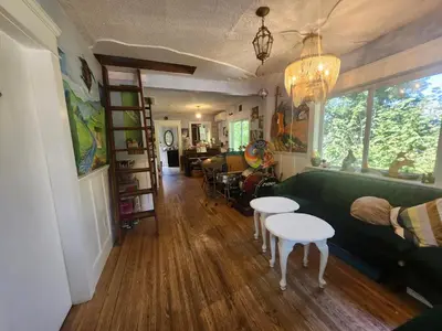 a living room with a green couch and tables at Trout House by Trout Lake in Vancouver
