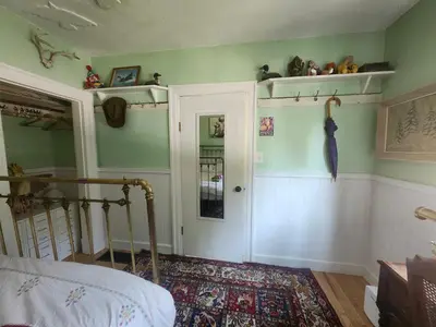 a bedroom with green walls and a bed and a door at Trout House by Trout Lake in Vancouver