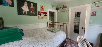 a bedroom with a bed in a room with green walls at Trout House by Trout Lake in Vancouver
