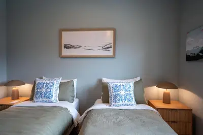 two twin beds in a room with two lamps at Ghost Peak Chalet - Ski-In Access in Port Mann
