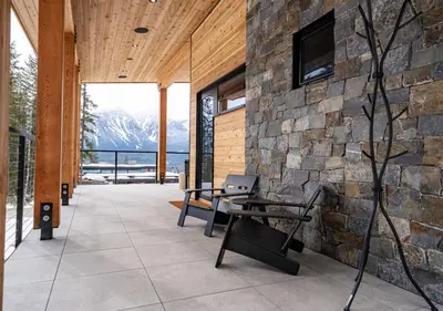 a room with two benches and a stone wall at Ghost Peak Chalet - Ski-In Access in Port Mann