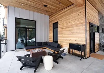 a patio with a couch and chairs and a stove at Ghost Peak Chalet - Ski-In Access in Port Mann