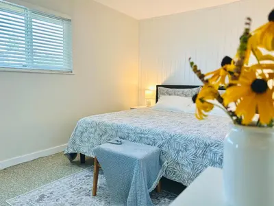 a bedroom with a bed and a vase with a plant at 4BR 2BA Downtown-View Cozy House with Parking, Pet-Free in Vancouver