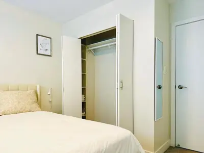 a bedroom with a bed and a closet at 4BR 2BA Downtown-View Cozy House with Parking, Pet-Free in Vancouver