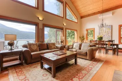 a living room with a couch and a table at Custom Built Home on the Beach in Nelson