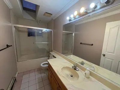 a bathroom with a sink and a toilet and a mirror at Delta Guest House - Scott Rd & Rapid Transit - Airport 20 Min - Free Parking & Fast Wi-Fi in Delta
