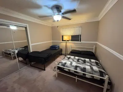 a bedroom with two beds and a ceiling fan at Delta Guest House - Scott Rd & Rapid Transit - Airport 20 Min - Free Parking & Fast Wi-Fi in Delta