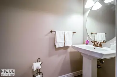 a white bathroom with a sink and a mirror at 5BD Jungle Oasis - HotTub - BBQ - King Bed - Games - Garage in Edmonton